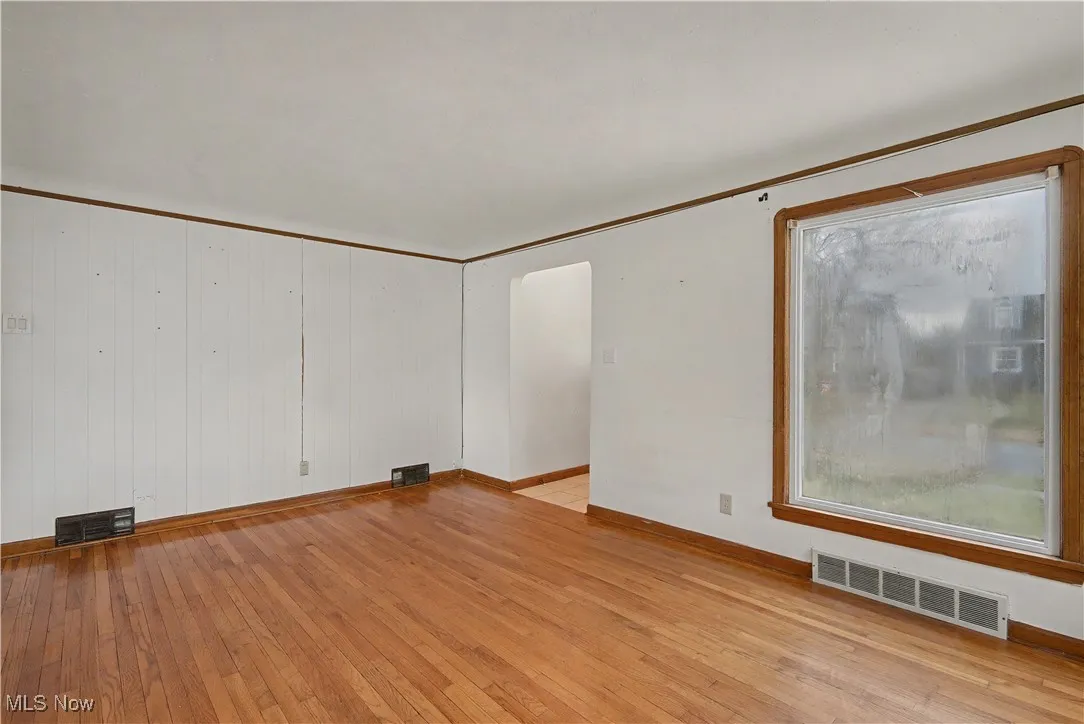 Unfurnished room featuring light wood-style flooring and crown molding