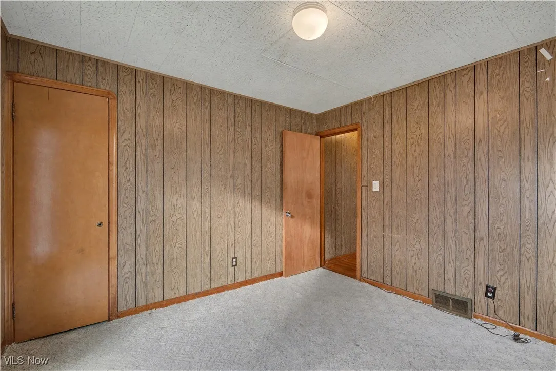 Unfurnished bedroom with wood walls
