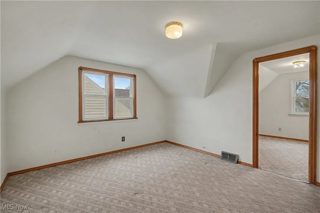 Bonus room featuring lofted ceiling and carpet floors