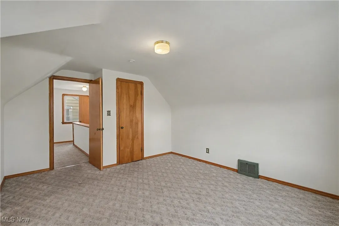 Bonus room with vaulted ceiling and carpet floors