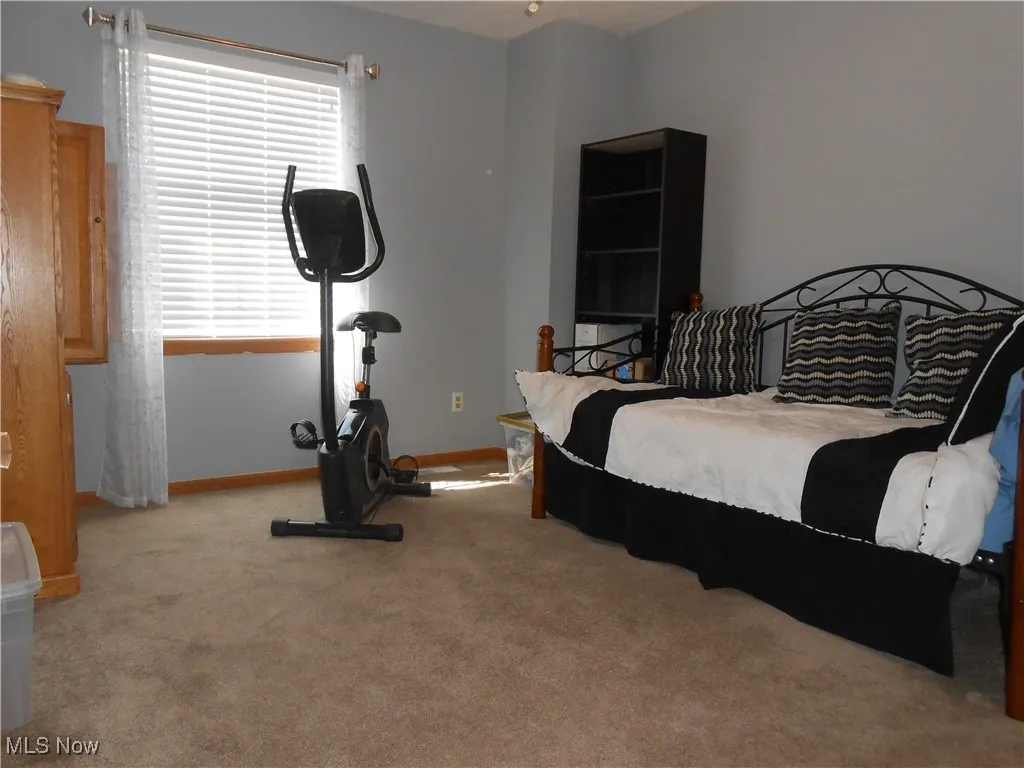 Bedroom with light carpet and baseboards