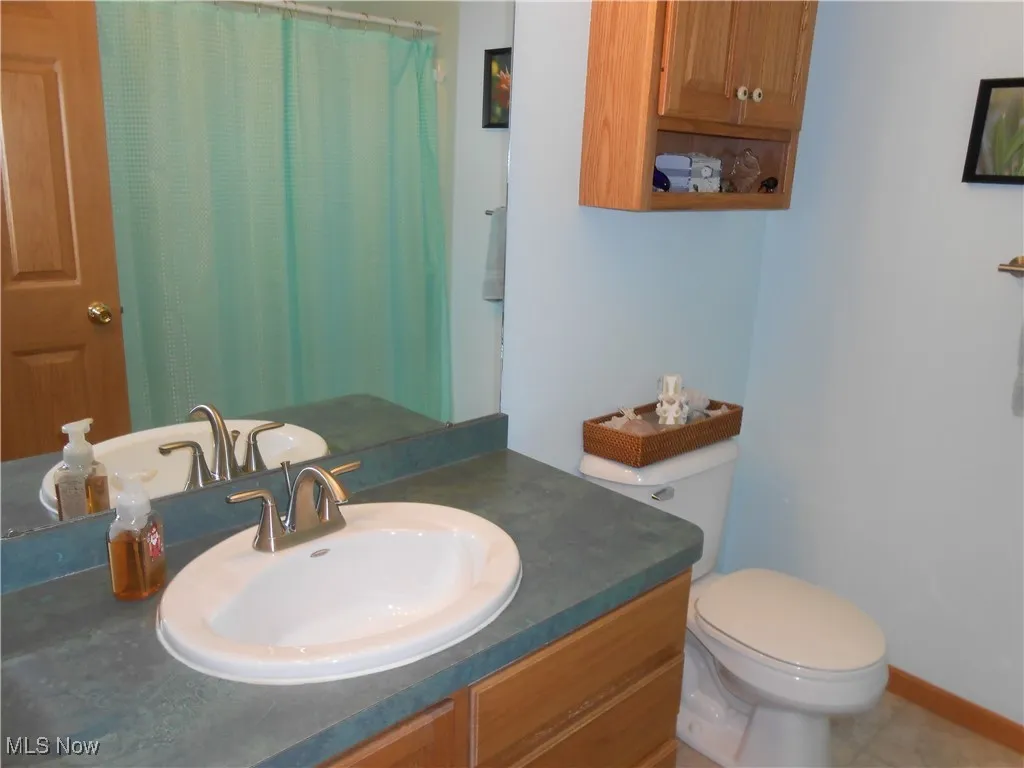 Bathroom featuring vanity, a shower with shower curtain, and tile patterned flooring