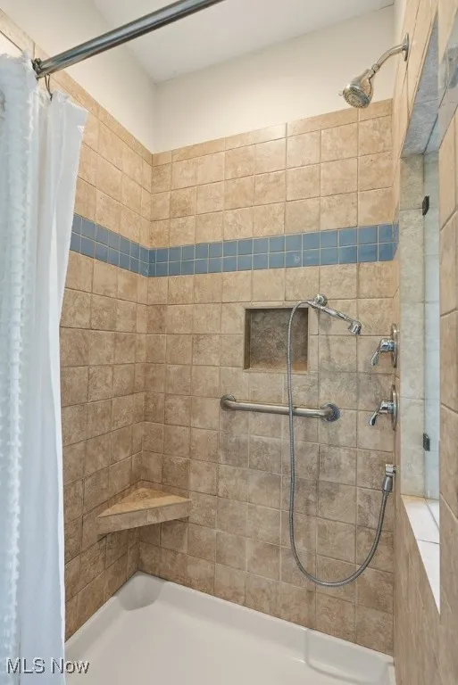 Full bath featuring a tile shower