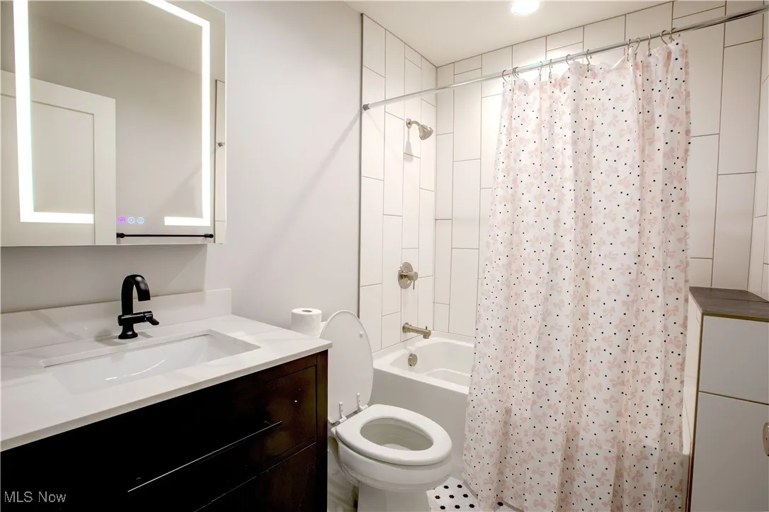 Bathroom with vanity and shower / bath combination with curtain
