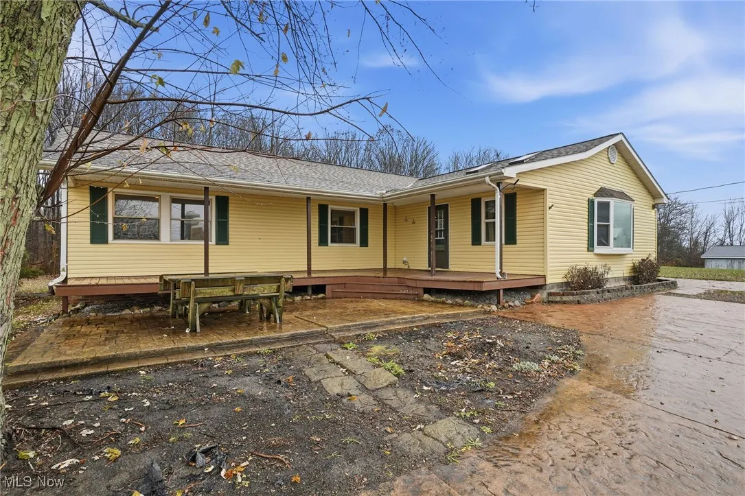View of front of home with roof with shingles and a deck