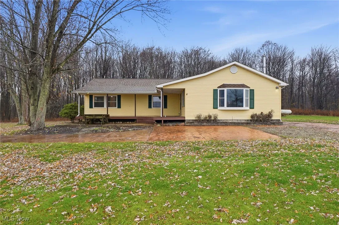 Ranch-style house featuring covered porch, a front lawn, and a shingled roof