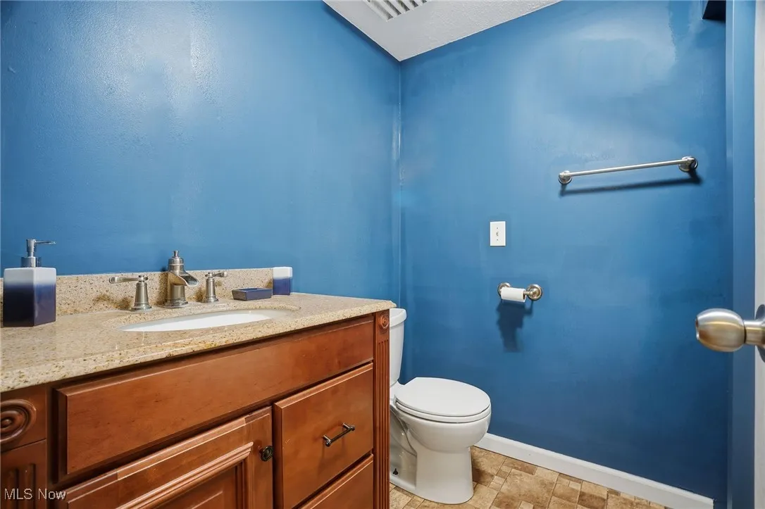 Half bathroom featuring vanity and toilet