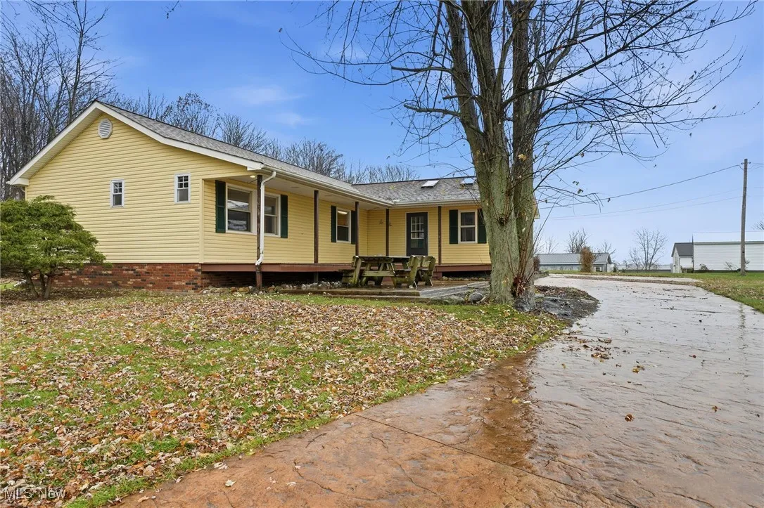 View of front of house featuring a patio and roof with shingles