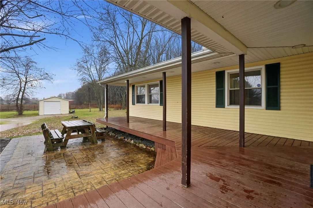 Wooden deck with a detached garage and an outbuilding