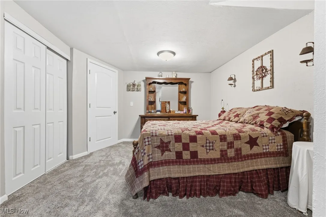 Carpeted bedroom featuring a closet and baseboards