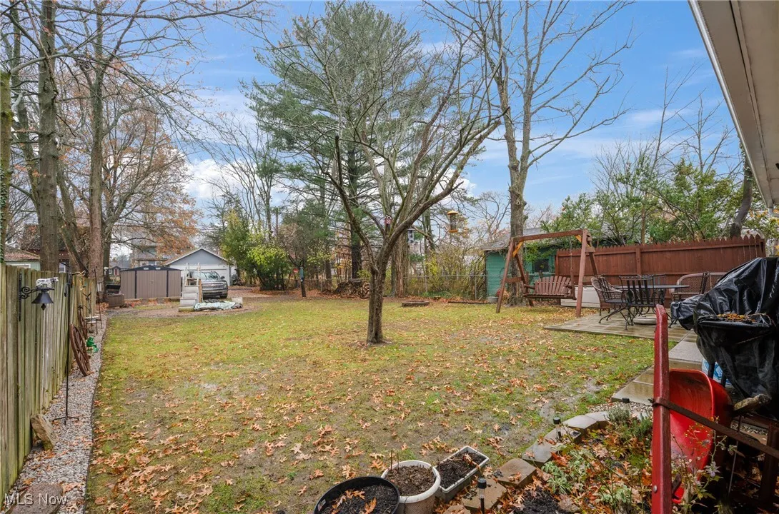 Fenced backyard featuring an outdoor structure and a patio