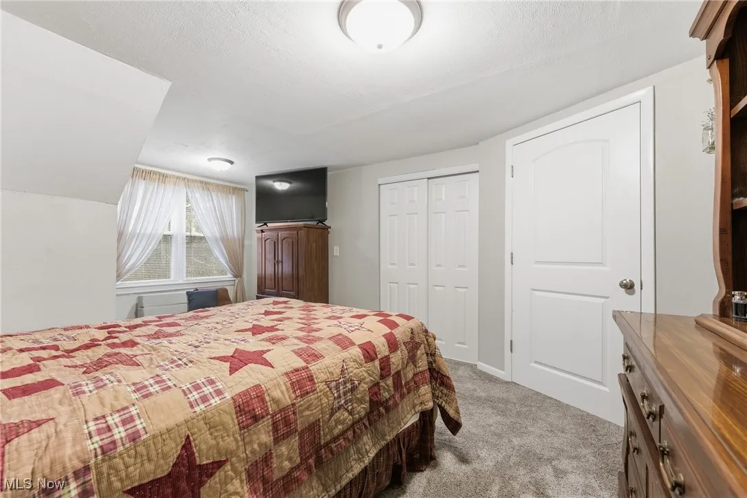 Carpeted bedroom featuring a closet