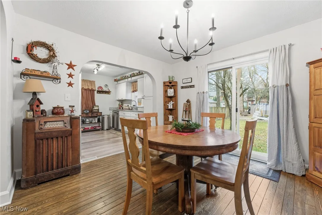 Dining area featuring arched walkways, hardwood / wood-style floors, and a chandelier