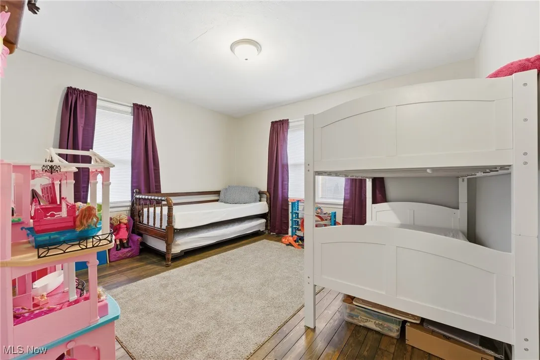 Bedroom featuring hardwood / wood-style flooring and multiple windows