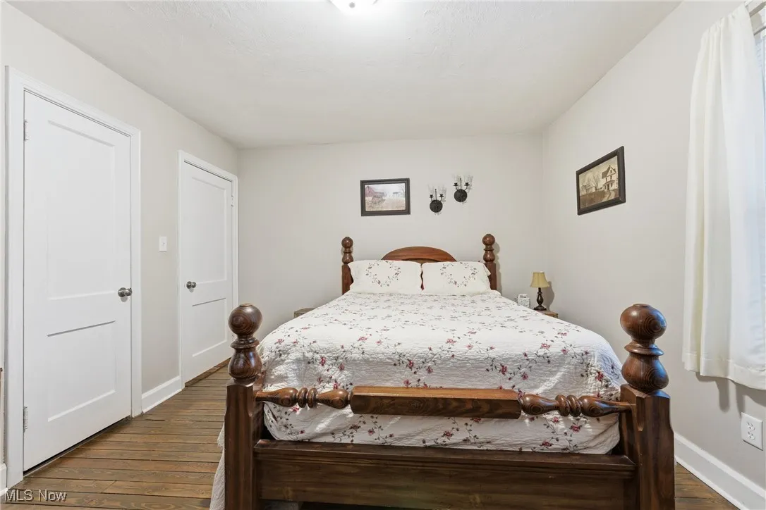 Bedroom featuring dark wood-style flooring and baseboards