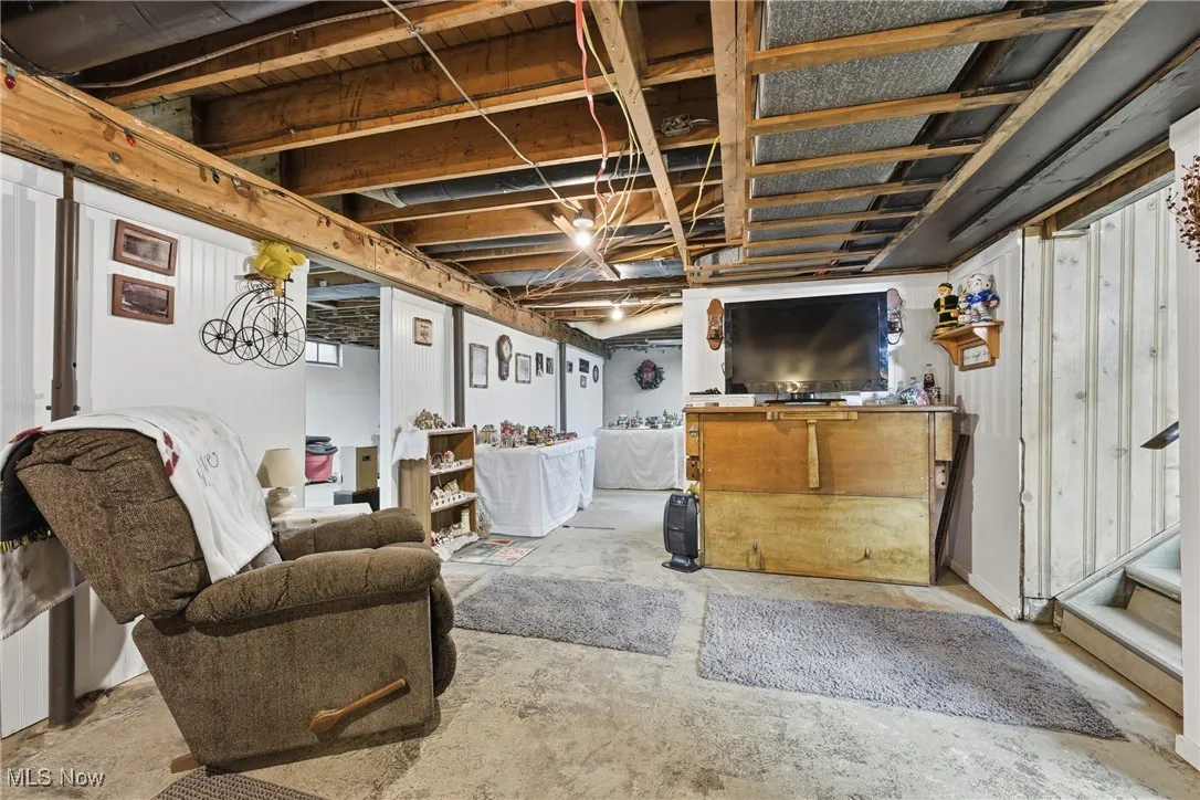 Unfinished below grade area featuring wood walls