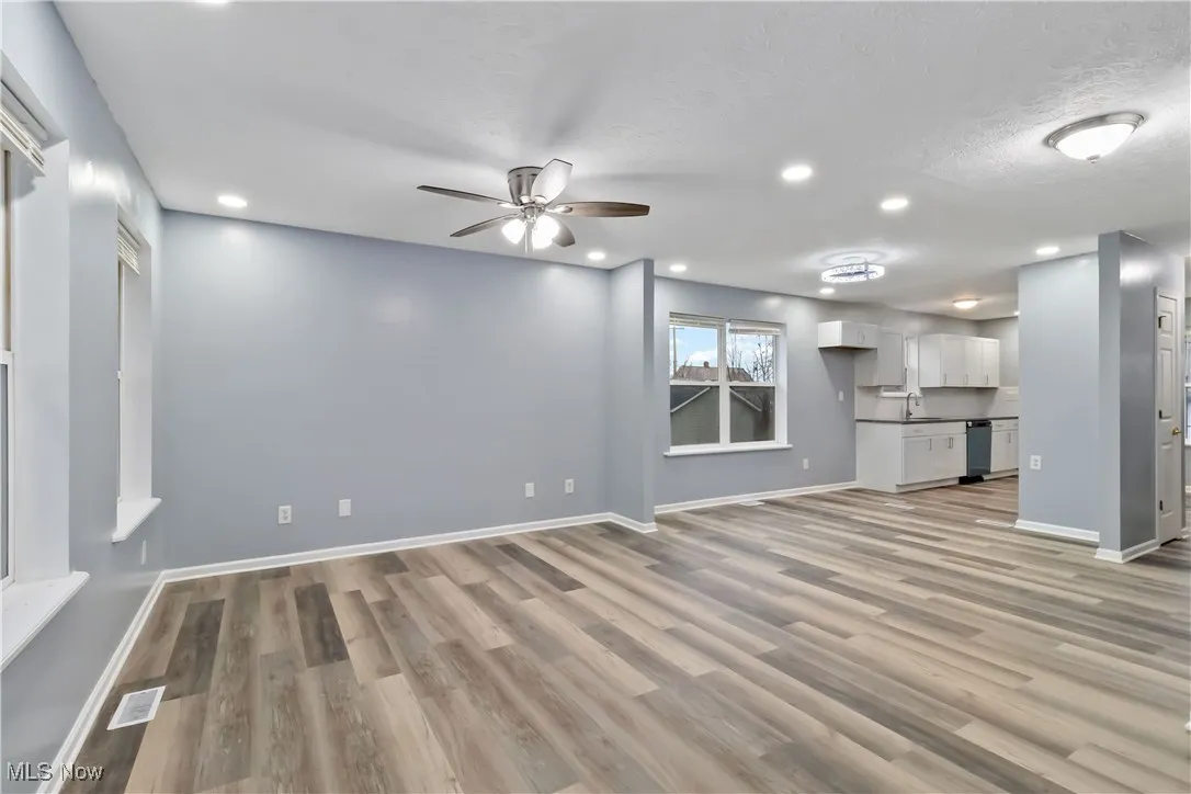 Unfurnished living room featuring a ceiling fan, recessed lighting, light wood finished floors, and a textured ceiling