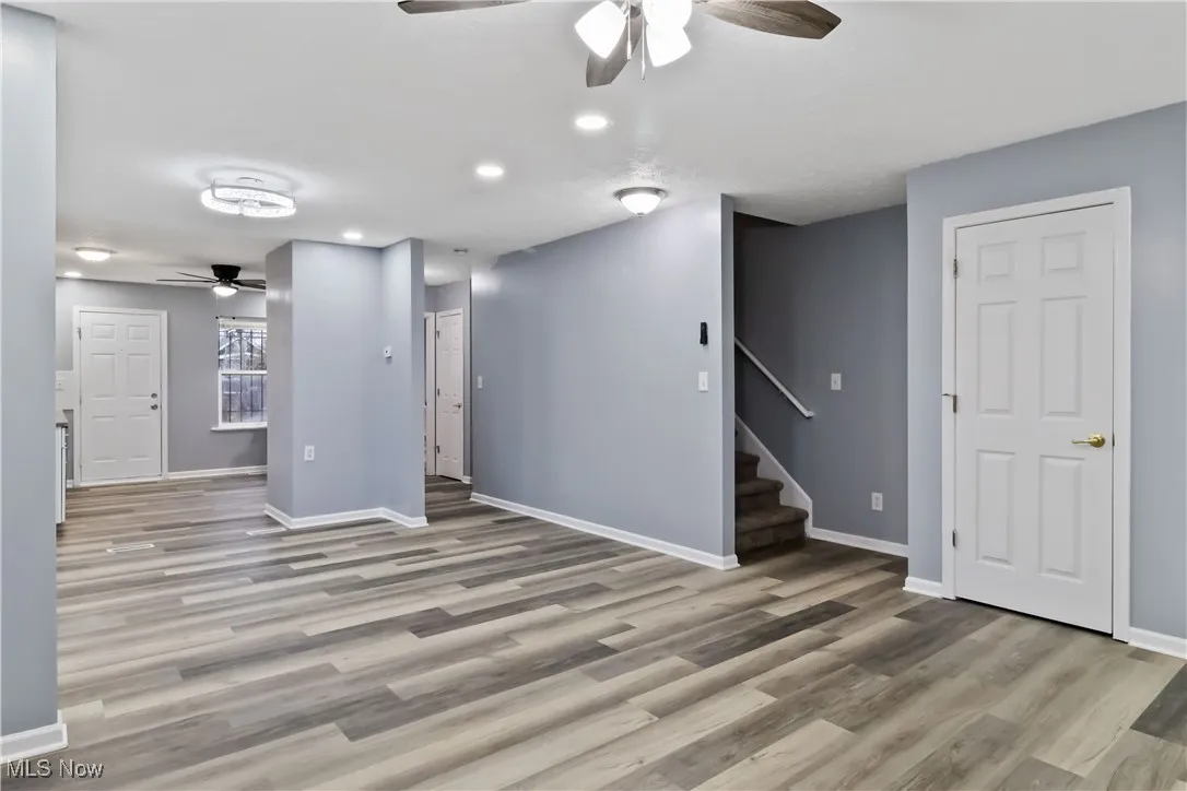 Below grade area featuring a ceiling fan, recessed lighting, stairs, and light wood-type flooring