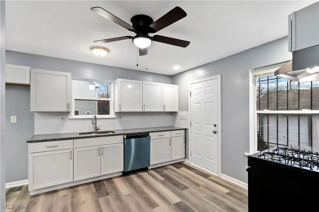 Kitchen featuring white cabinetry, dishwasher, ceiling fan, black gas stove, and light wood finished floors