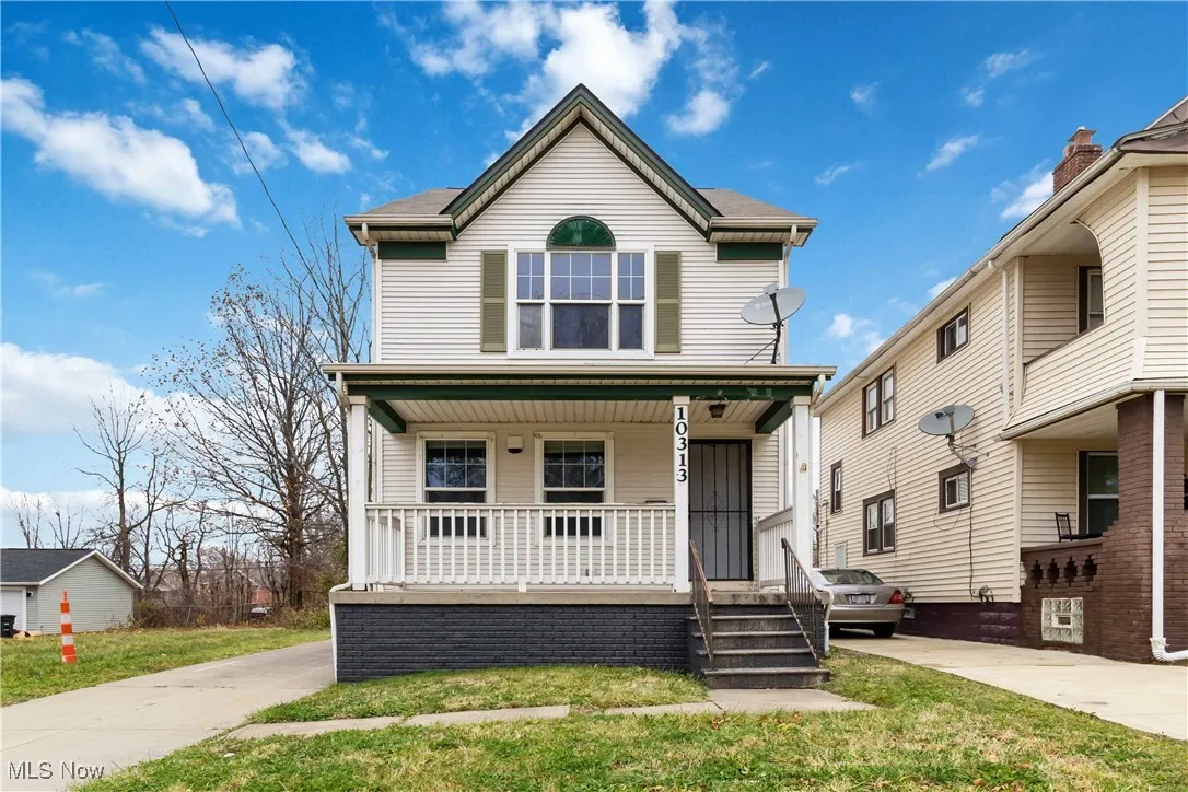 View of front of property with covered porch and a front lawn