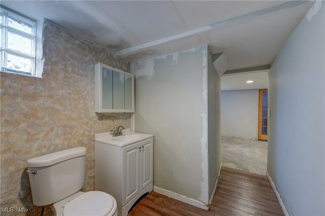 Half bathroom featuring vanity and dark wood-style floors