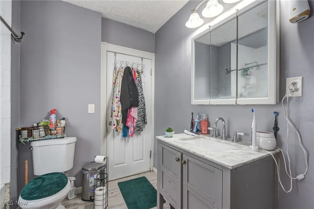 Bathroom with a textured ceiling and vanity