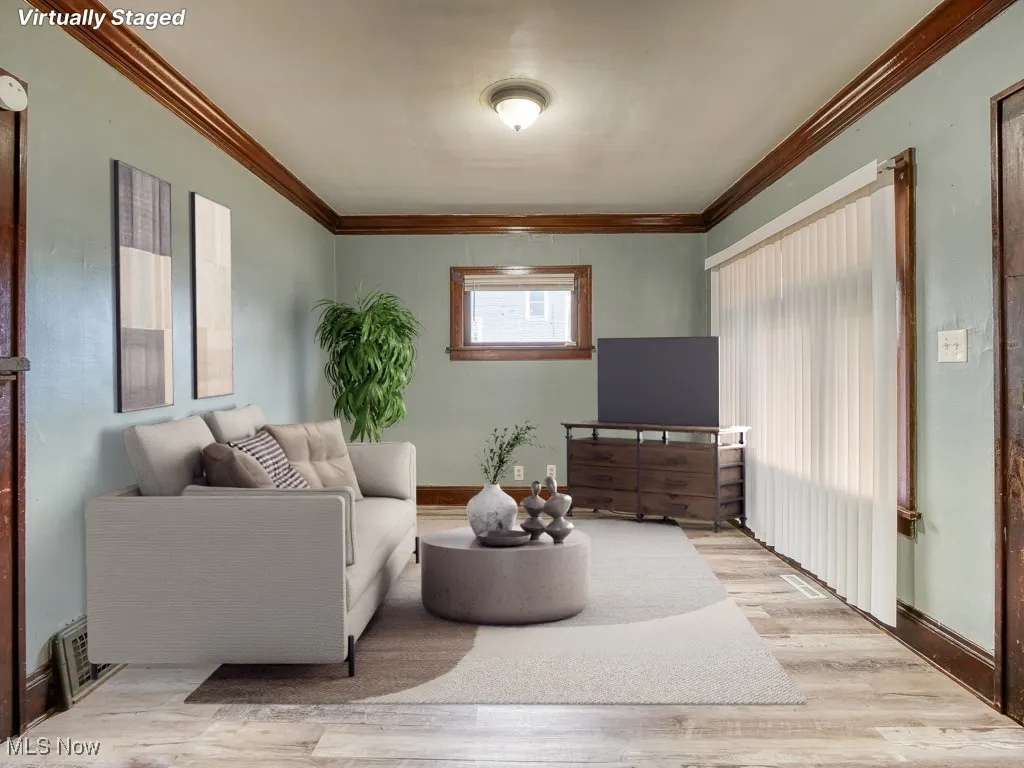 Living room featuring wood finished floors and ornamental molding
