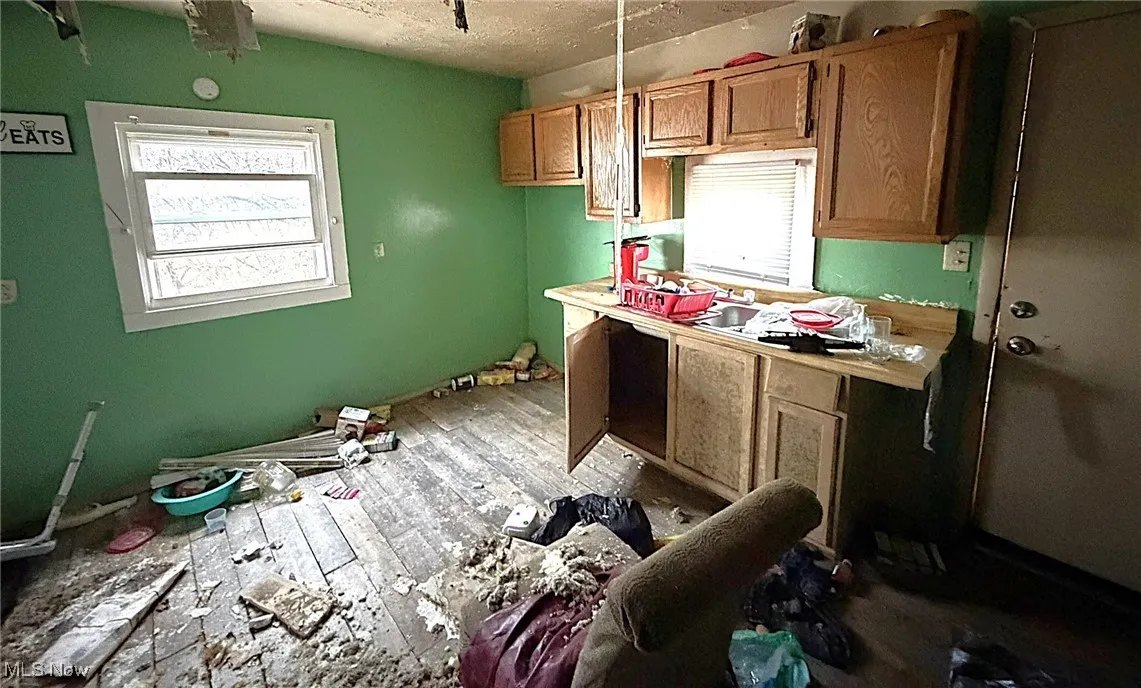 Kitchen featuring healthy amount of natural light, a textured ceiling, and brown cabinets