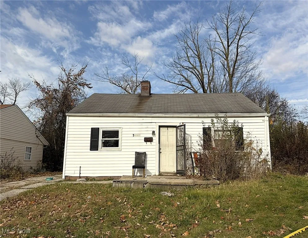 View of front of house with a chimney, a front yard, and a wooden deck