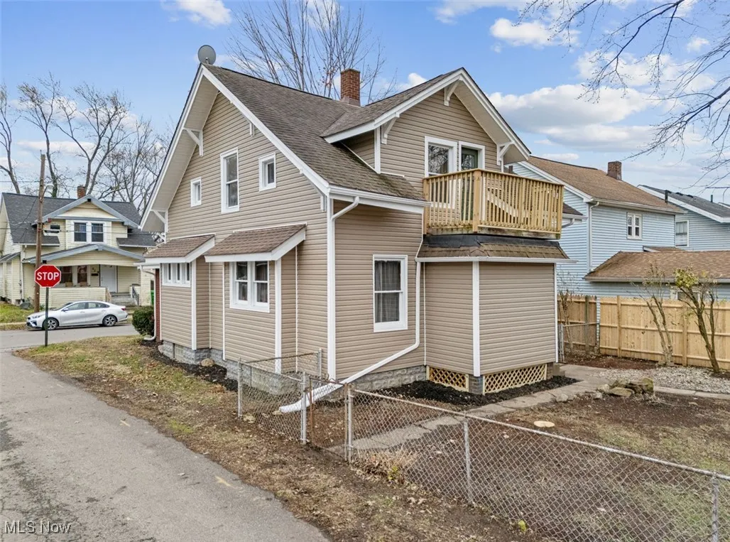View of home's exterior featuring a balcony, roof with shingles, and a chimney