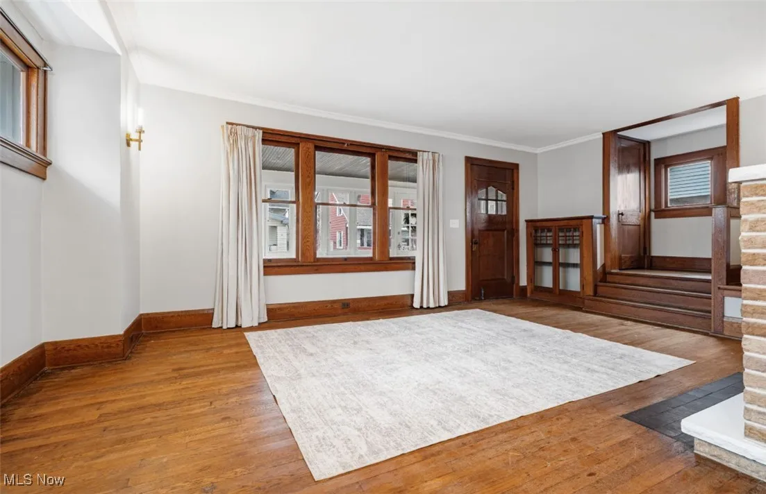 Entryway featuring hardwood / wood-style floors, crown molding, and stairway