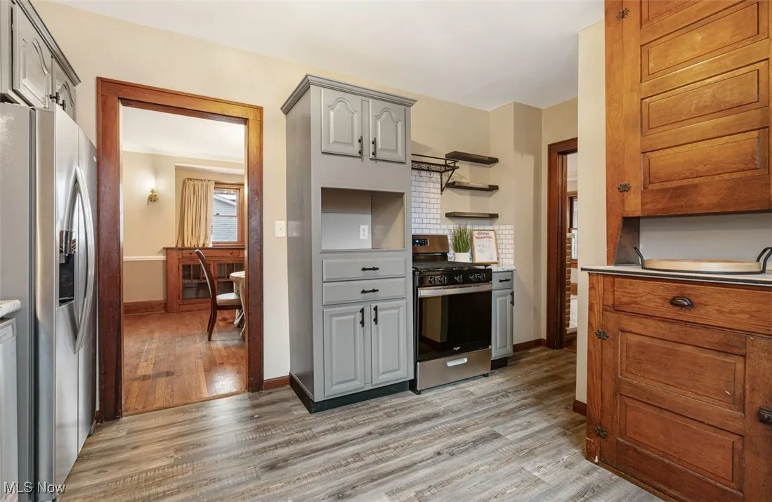 Kitchen with stainless steel appliances, gray cabinetry, light wood finished floors, and light countertops
