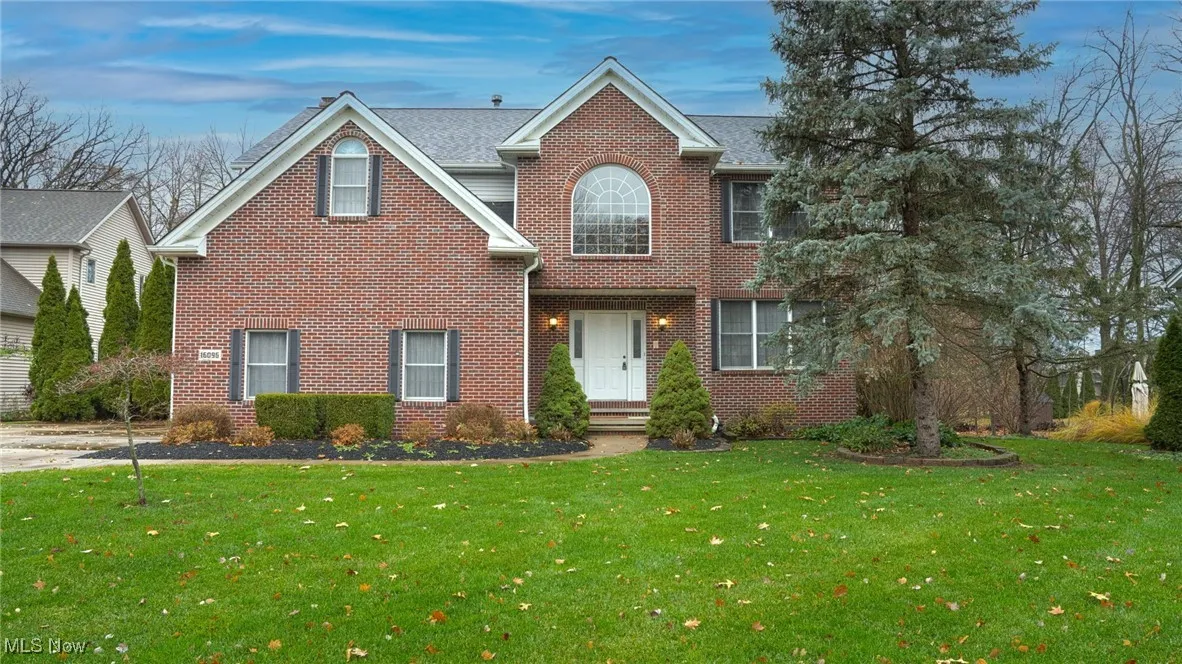 Traditional-style house featuring brick siding and a front lawn