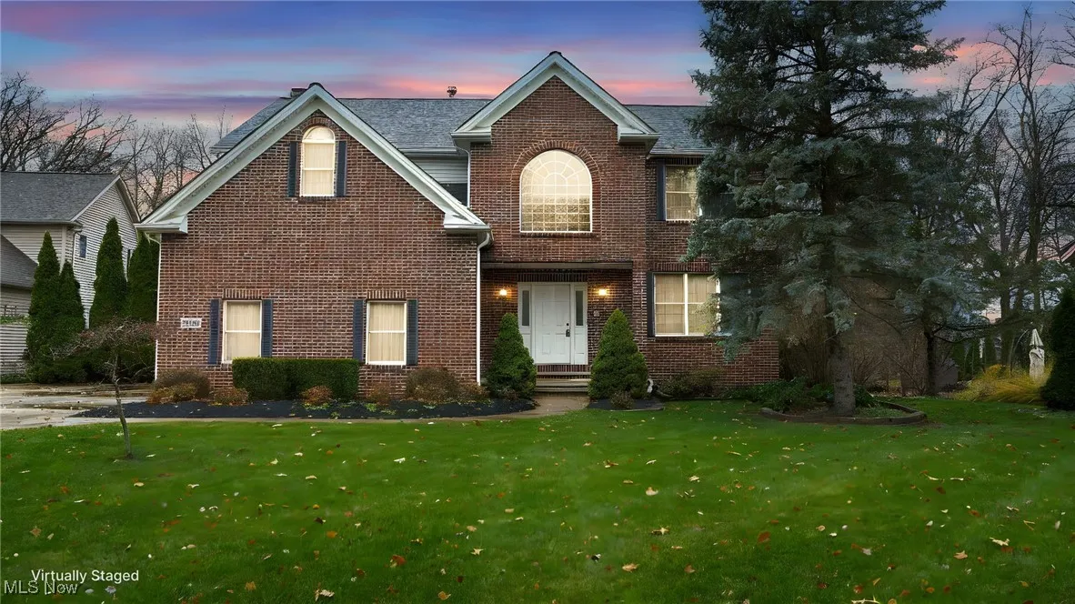 Traditional-style home with brick siding and a front lawn