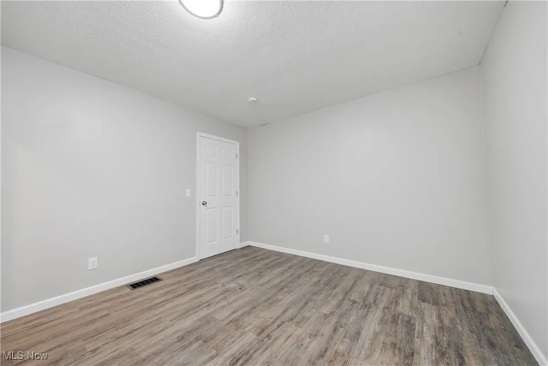 Spare room with a textured ceiling and wood finished floors