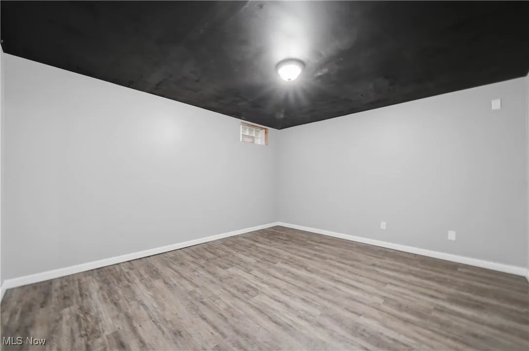 Spare room featuring wood finished floors and baseboards