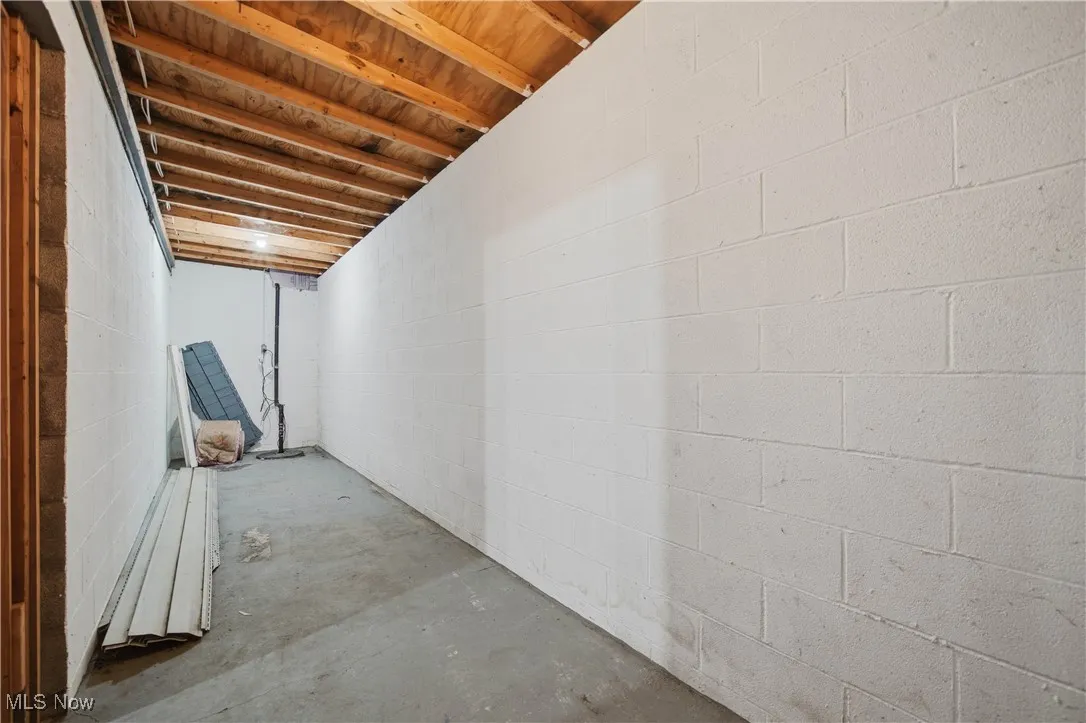 Unfinished basement with concrete block wall