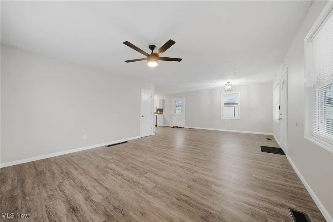 Empty room with light wood-type flooring and a ceiling fan