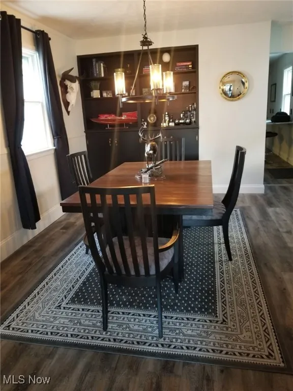 Dining area featuring dark wood-type flooring