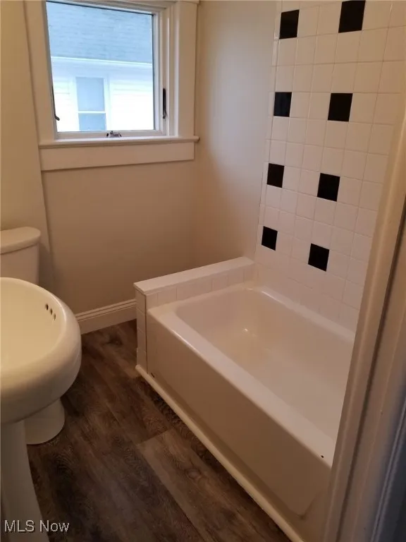 Bathroom with a bath and dark wood finished floors