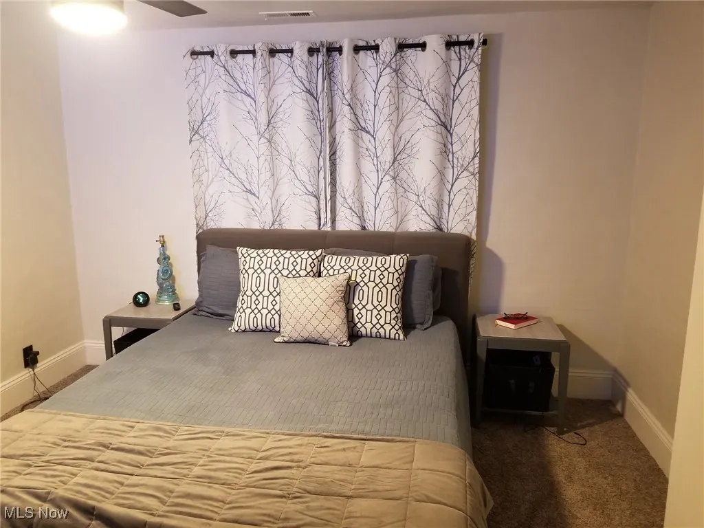 Carpeted bedroom featuring baseboards and ceiling fan