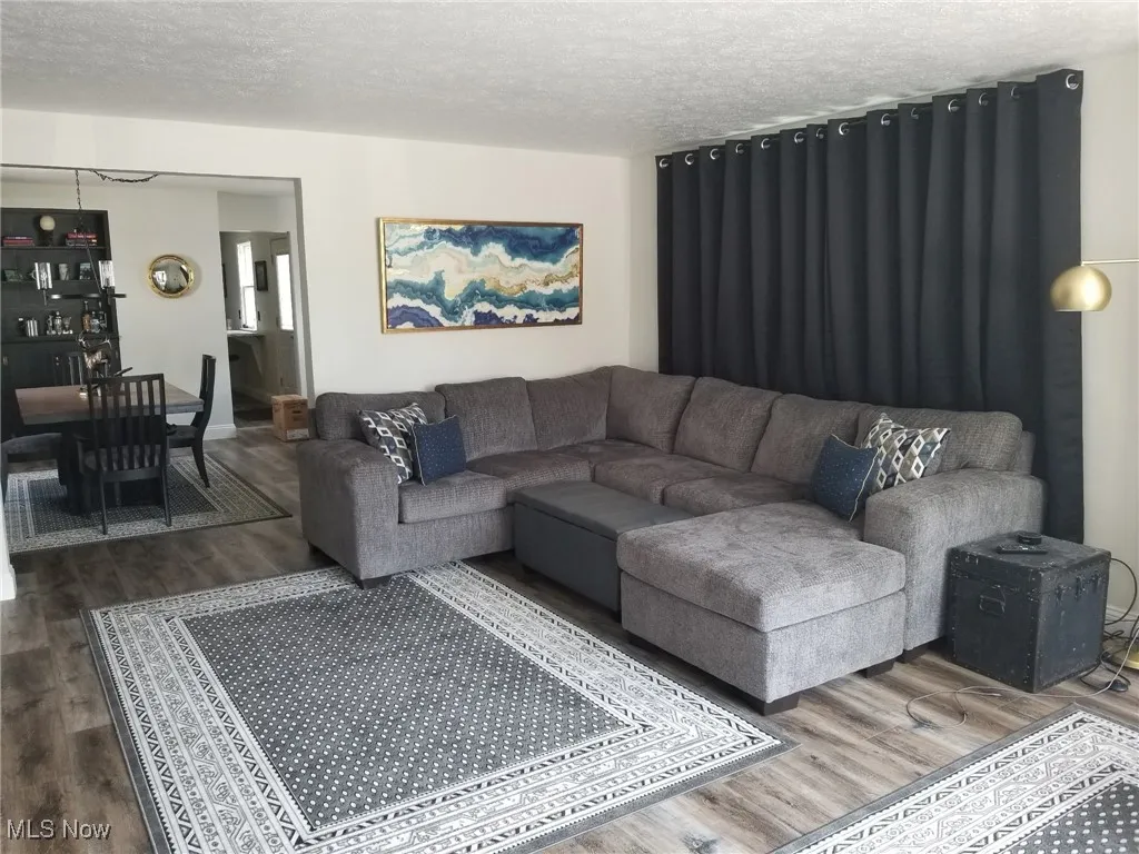 Living room with a textured ceiling and wood finished floors