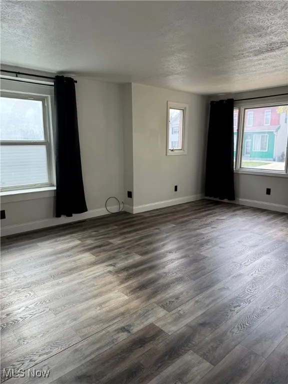 Empty room featuring a textured ceiling and wood finished floors