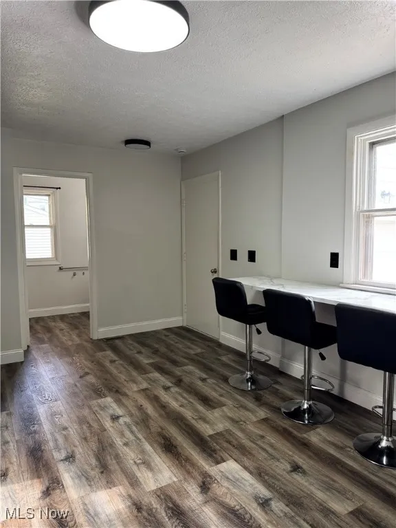 Office featuring a textured ceiling and dark wood finished floors