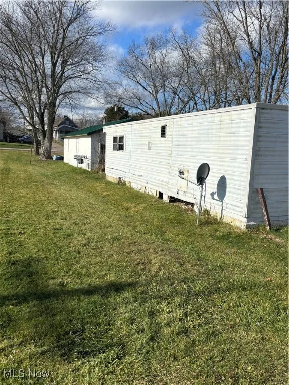 View of side of home featuring a yard