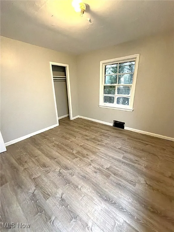Unfurnished bedroom with a closet and wood finished floors