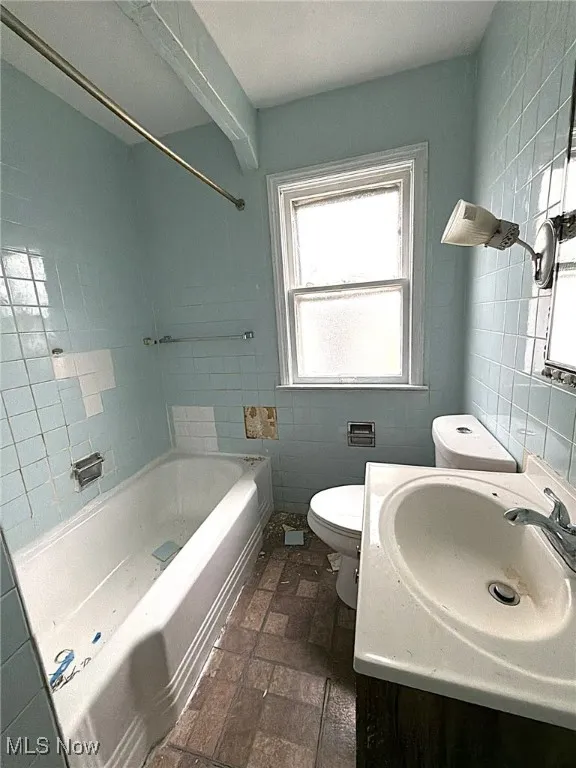 Full bathroom featuring vanity, tile walls, and shower / bath combination
