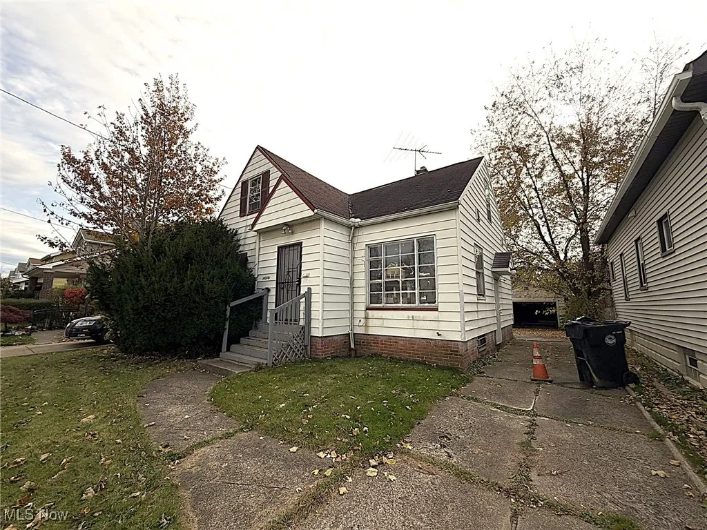 View of front of house with a front lawn and roof with shingles