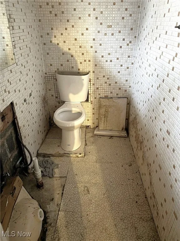 Half bathroom with tile walls