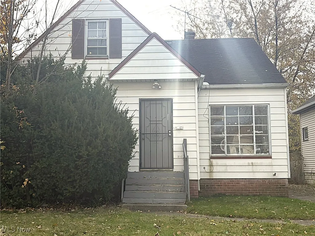 View of front of property with entry steps, a front yard, and a chimney
